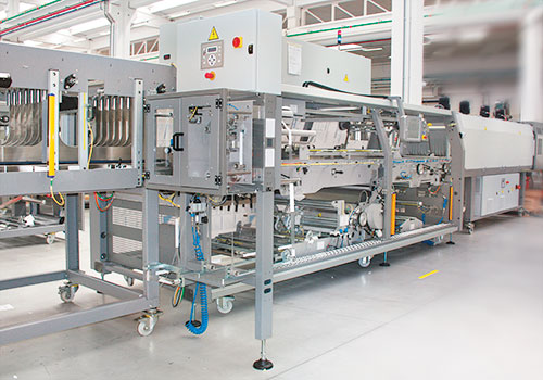 Film shrink wrappers with in-line infeed
